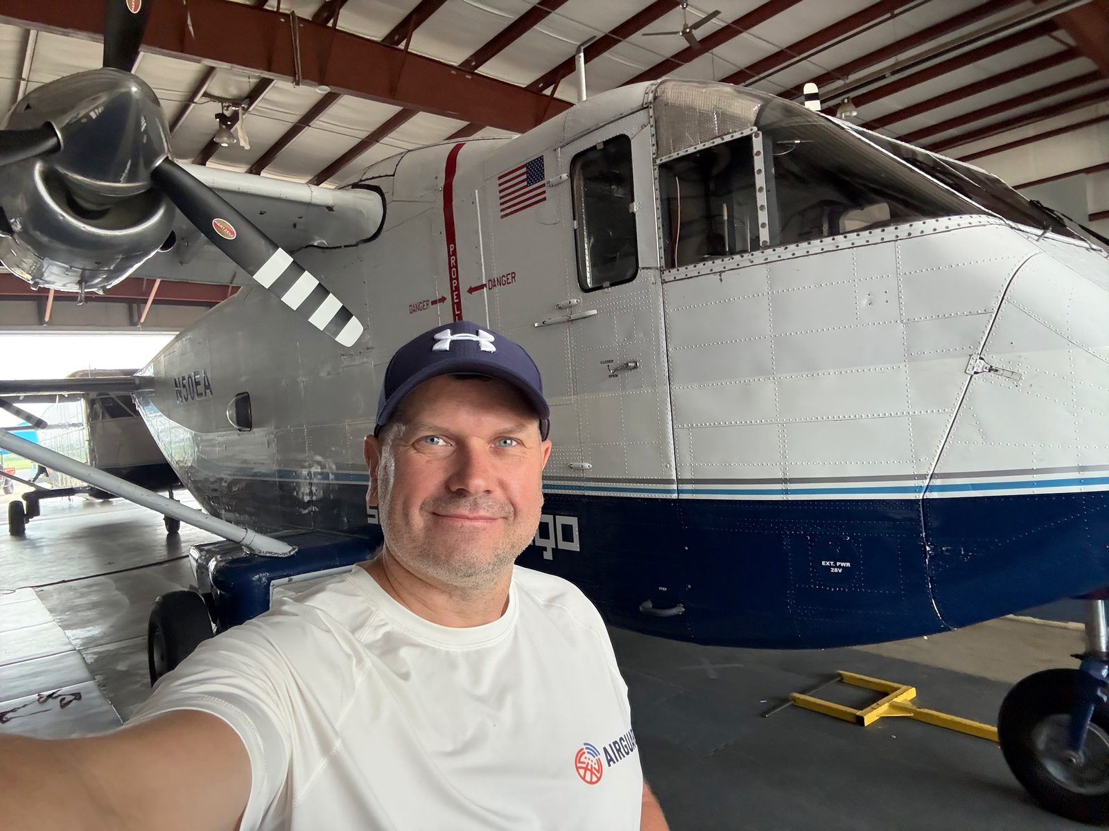 Andrey Baykov in front of a jump aircraft in the hangar